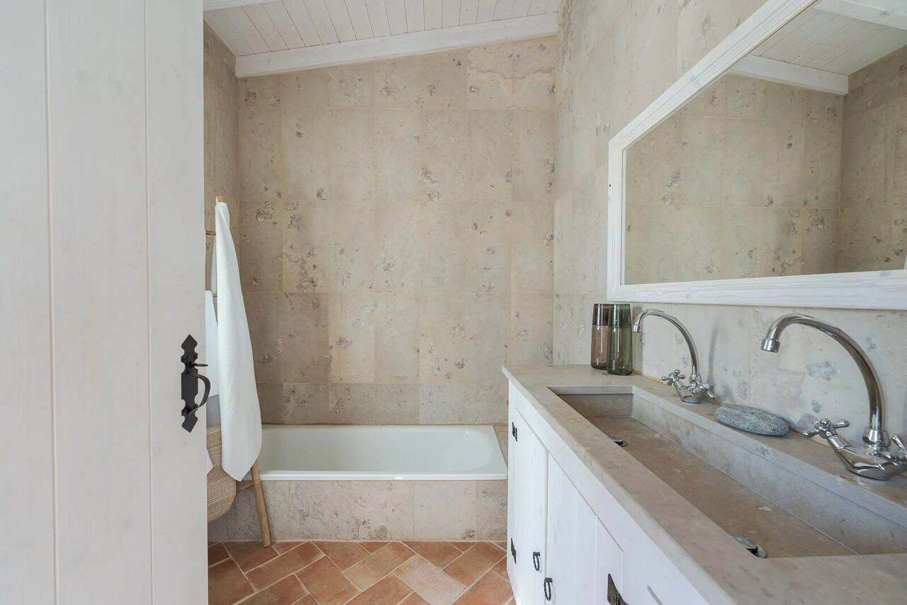 A stone bathroom with bath