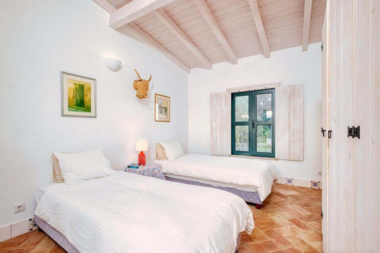 A twin bedroom with green shutters